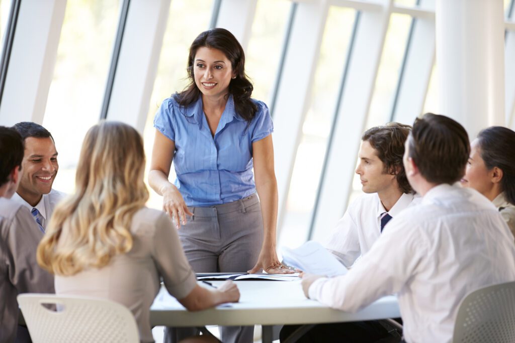 Young female team leader brainstorming group of employees