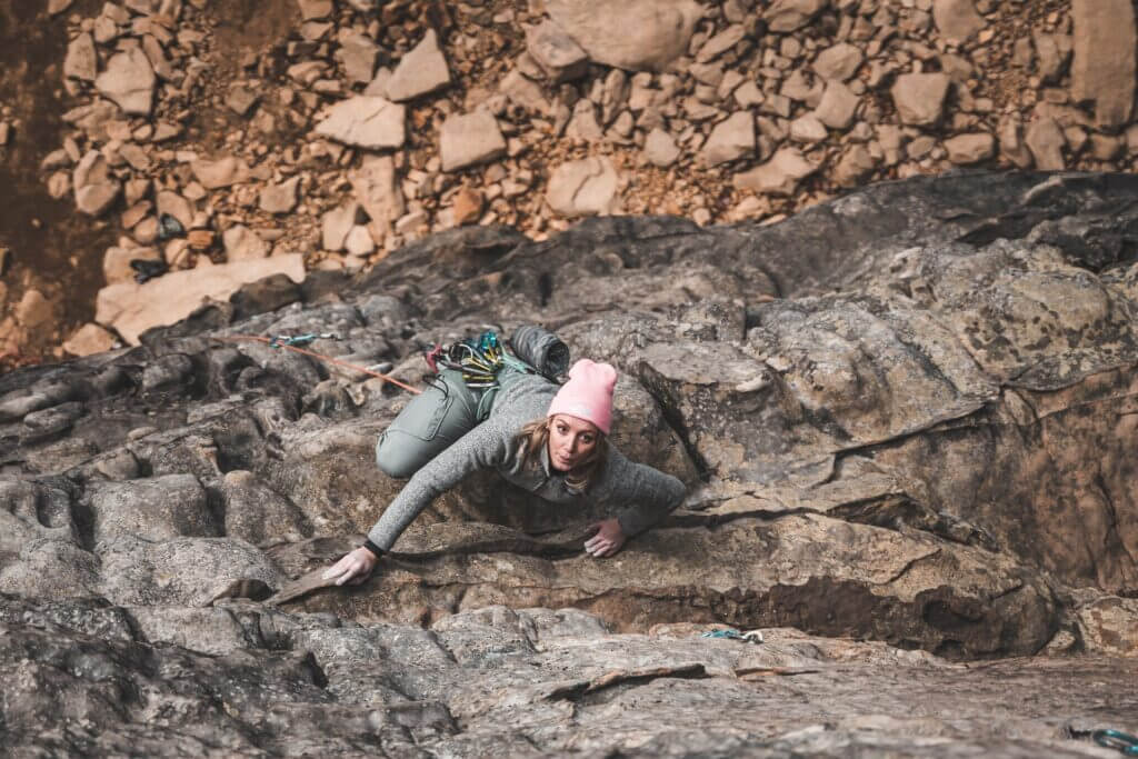 woman climbing rough stoned hill