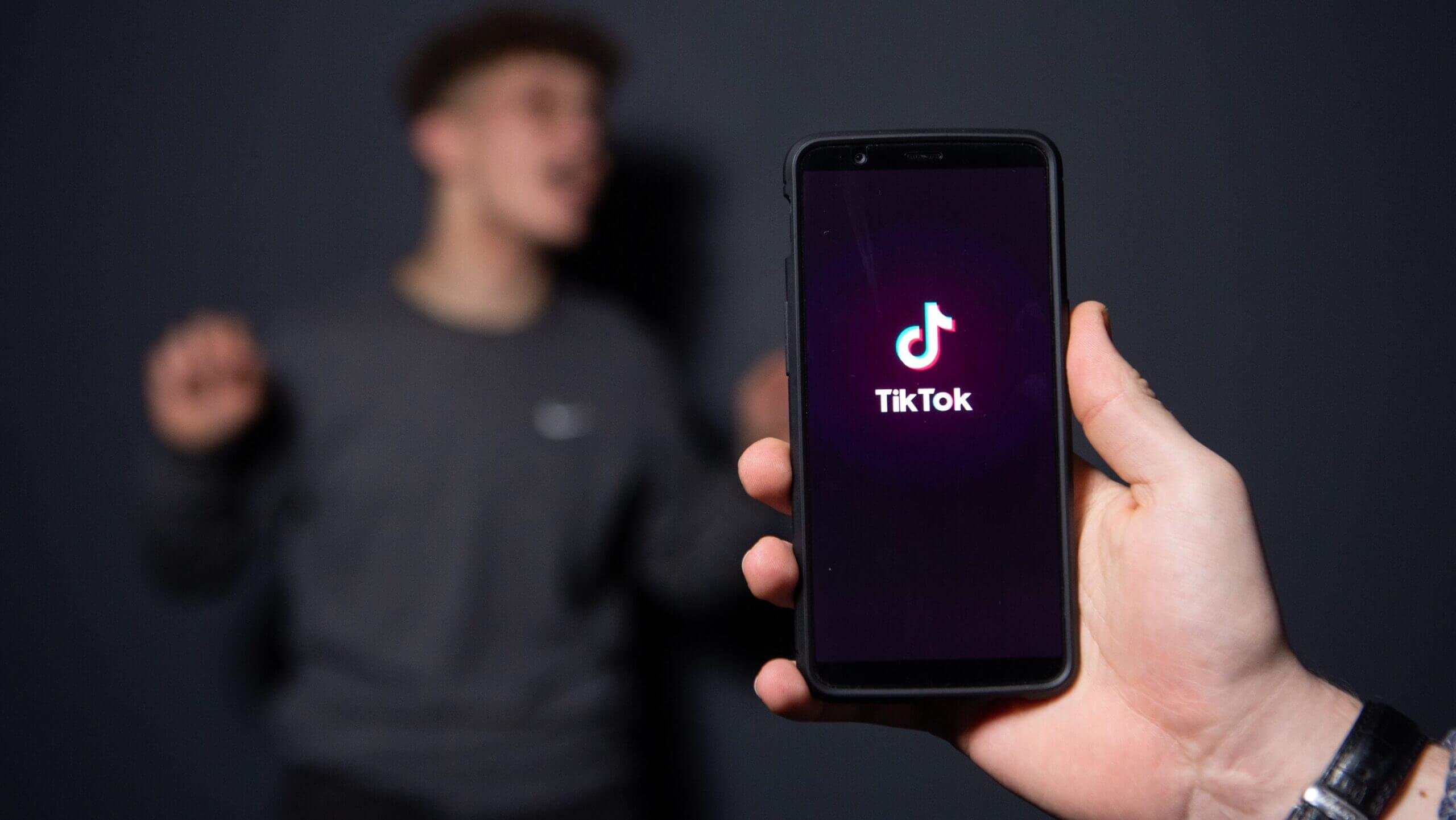 Tik Tok app open on mobile background a person standing
