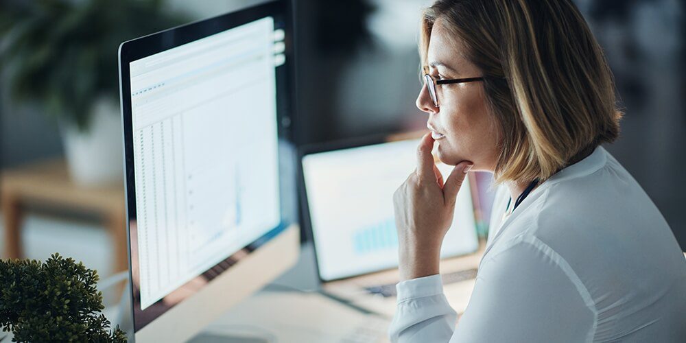woman looking at the screen thinking how increase efficiency with robotic process automation