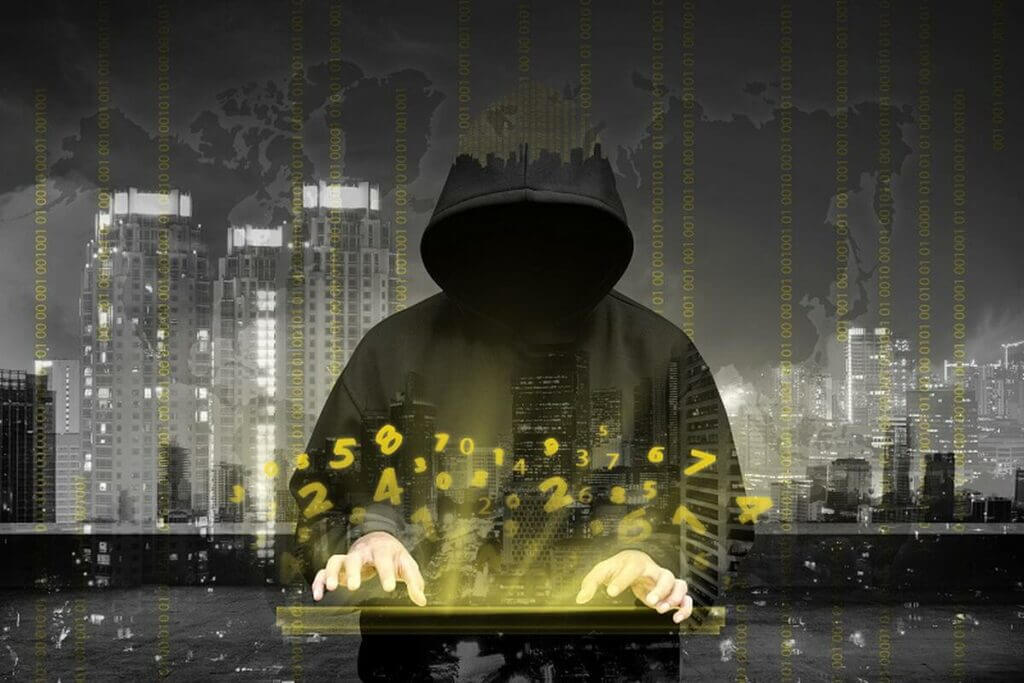 IT hacker wearing black hoodie working on Dark web coding